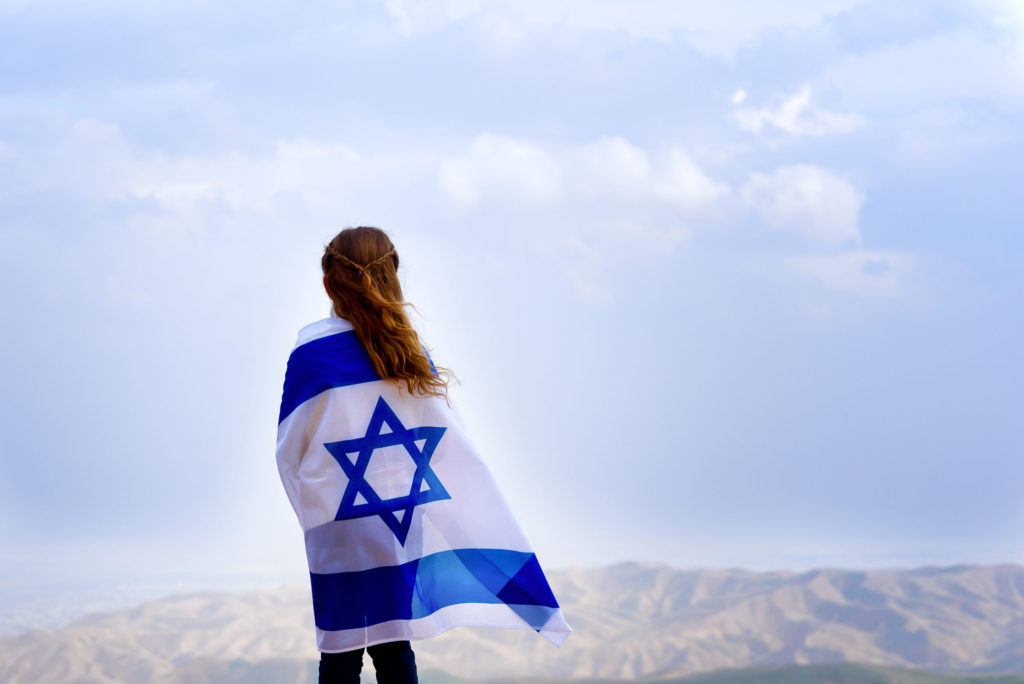 Jewish girl standing draped with flag